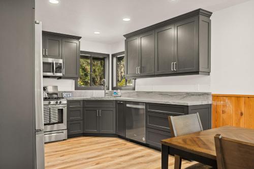 a kitchen with gray cabinets and a wooden table at Pine Oaks Cabin in Lake Arrowhead