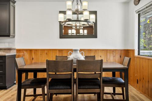 a dining room table with chairs and a chandelier at Pine Oaks Cabin in Lake Arrowhead