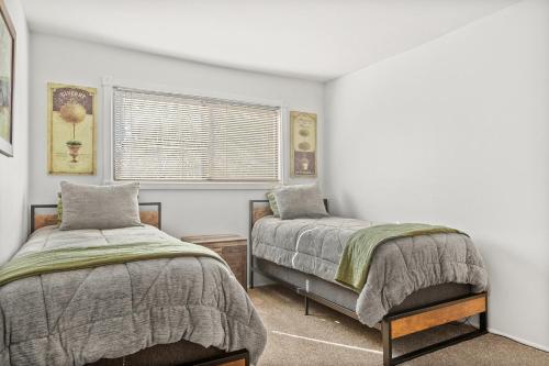 a bedroom with two beds and a window at Pine Oaks Cabin in Lake Arrowhead