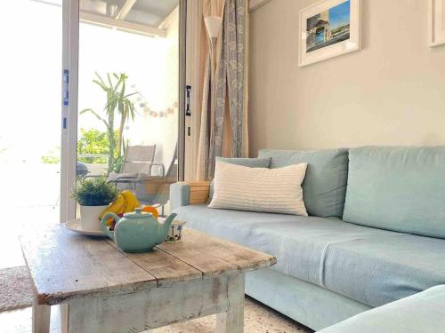a living room with a blue couch and a coffee table at Angelina retreat close to beach in Pyla