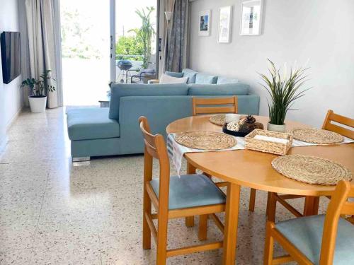 a living room with a table and a blue couch at Angelina retreat close to beach in Pyla