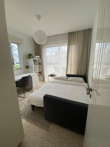 a bedroom with a large bed and a desk at Angelina retreat close to beach in Pyla