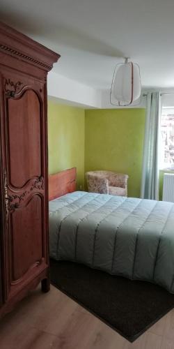 une chambre avec un lit et une armoire en bois dans l'établissement Résidence avec parking 5 mm Colmar, à Horbourg-Wihr