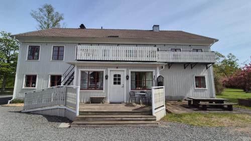 a white house with a porch and a picnic table at Pensionat Klåvasten in Skövde