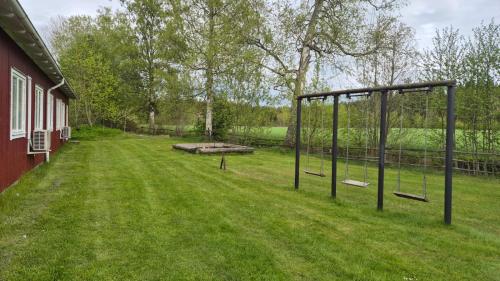 a swing set in a yard next to a house at Pensionat Klåvasten in Skövde