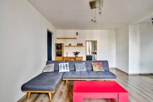 un salon avec un canapé bleu et une table rouge dans l'établissement Bel appartement St Michel, à Toulouse