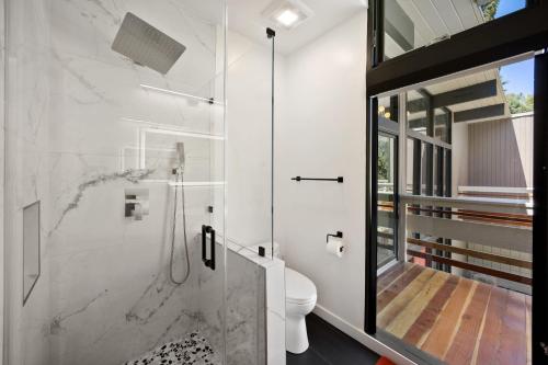 a white bathroom with a shower and a toilet at New Listing Architectural Villa by Colby & Conrad in Los Angeles