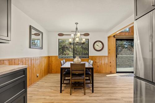 a kitchen with a table and chairs and a clock on the wall at Pine Oaks Cabin in Lake Arrowhead