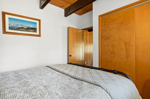 a bedroom with a bed and a wooden door at Pine Oaks Cabin in Lake Arrowhead