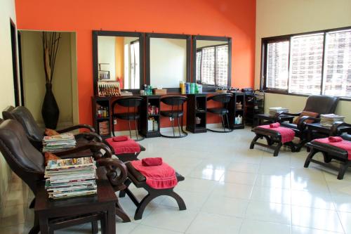 a waiting room with chairs and tables and red walls at Grand Sinar Indah in Legian