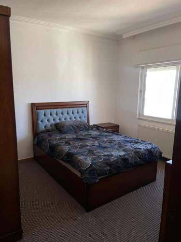 a bedroom with a bed and a window at شقة مفروشة للإيجار الجبيهة in Amman