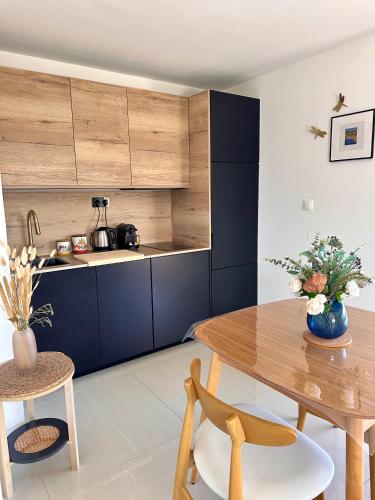 a kitchen with a wooden table and blue cabinets at Villa Grand Baie in Agay - Saint Raphael