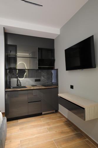 a kitchen with stainless steel cabinets and a flat screen tv at Apartments Romario in Sarandë
