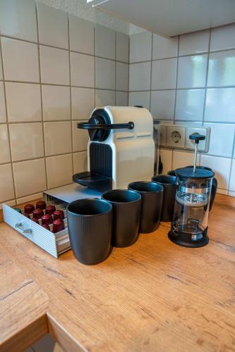 a row of cups sitting on top of a kitchen counter at Grill & Chill-Kressbronn Deluxe in Kressbronn am Bodensee