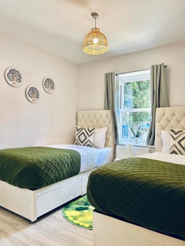 a bedroom with two beds and a window at Two Dover Ferry Apartments - sleep 8 with private terrace and castle views in Kent