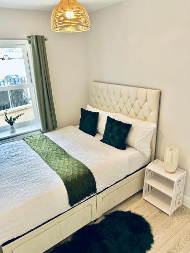 a bedroom with a large bed with a window at Two Dover Ferry Apartments - sleep 8 with private terrace and castle views in Kent