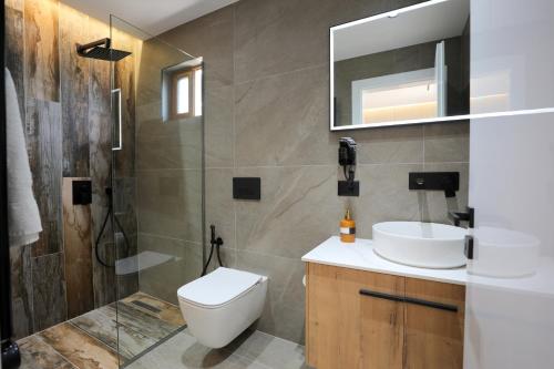 a bathroom with a toilet and a sink and a shower at Apartments Romario in Sarandë