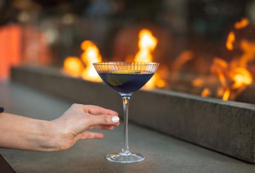 a hand holding a wine glass with a blue drink at Hilton Knoxville in Knoxville