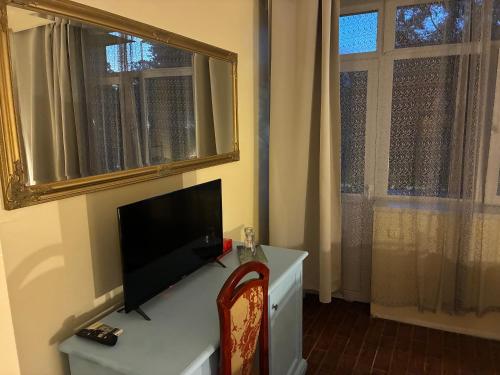 a living room with a tv on a desk with a window at ElStefanino House in Eforie Nord