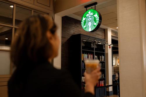 a woman holding a glass of beer in a store at Hilton Knoxville in Knoxville