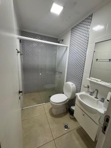 a bathroom with a toilet and a sink and a shower at Apart Hotel BRIANA in Puerto Iguazú