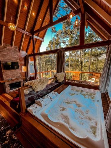 a large tub in a room with a large window at Pousada Vale da Neve in Urubici