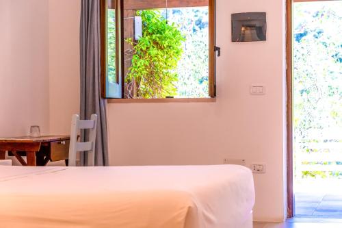 a bedroom with a bed and a table and a window at Shanti Home in Vieste