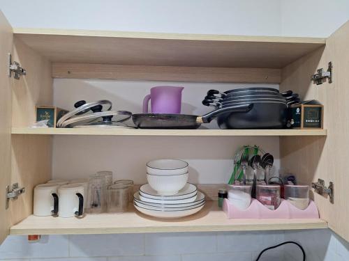 a cupboard filled with dishes and utensils at Kiambu road Green Zone Macedonia in Kiambu