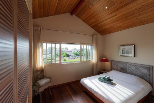 une chambre avec un grand lit et une fenêtre dans l'établissement Superbe maison lumineuse, au calme avec piscine, à La Teste-de-Buch