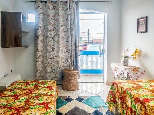 a room with two beds and a door to a balcony at Sobrado Azul com Piscina in Boituva