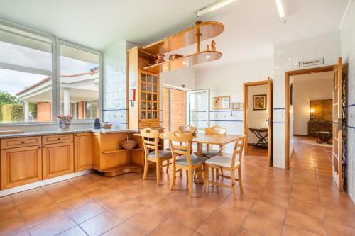 a kitchen with a wooden table and chairs at Solar de Prado - by Proguest in Vila de Prado