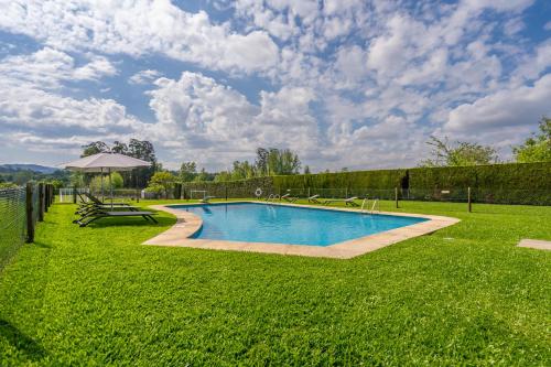 a swimming pool in the middle of a green yard at Solar de Prado - by Proguest in Vila de Prado