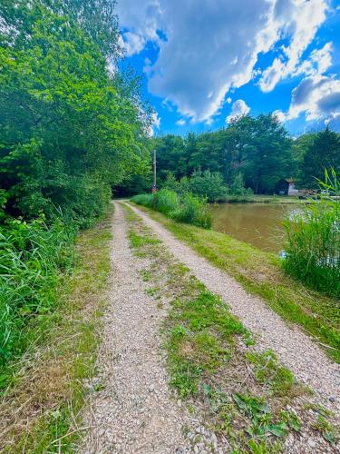un chemin de terre à côté d'une rivière arborée dans l'établissement Cabane Lachapelle sous chaux, à Lachapelle-sous-Chaux