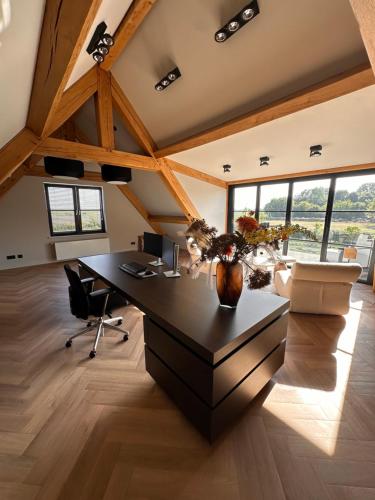 an attic office with a desk and chairs at Suite Ouddorp - 2 pers in Ouddorp