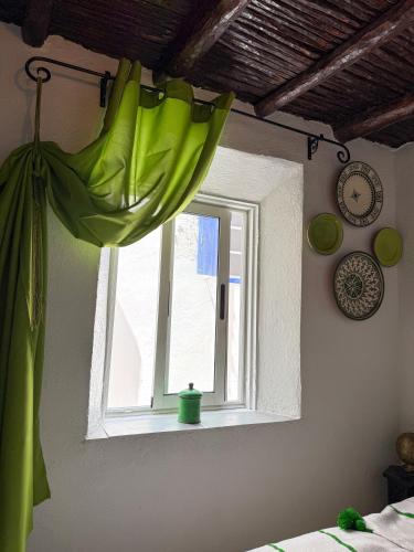 a window with a green curtain in a room at Mog'ador bleue in Essaouira