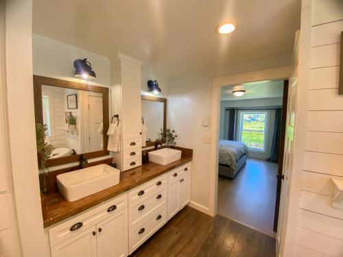 a bathroom with two sinks and a large mirror at Sundance Countryside Retreat in Sumner