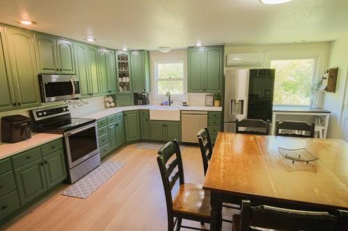 a kitchen with green cabinets and a table with chairs at Sundance Countryside Retreat in Sumner