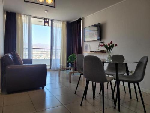 a living room with a table and chairs and a couch at Característico departamento 2 habitaciones, capacidad 4 y 5 personas, excelente vista de la ciudad y mar in Antofagasta