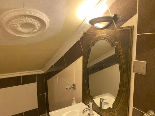 a bathroom with a mirror and a sink at The Manor in Lomé