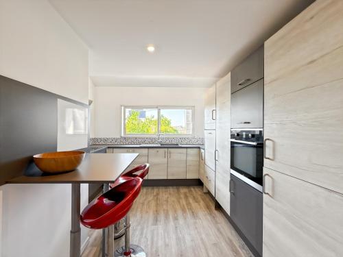 une cuisine avec une table et une chaise rouge dans l'établissement Le Calypso - Duplex Paisible - Coeur de Saint Malo, à Saint-Malo