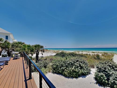 a wooden walkway to a beach with chairs and the ocean at Blue Heron in Pensacola Beach