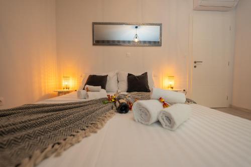 a bedroom with two large white beds with flowers on them at Pool and Breakfast Apartments Villa Maro in Novalja