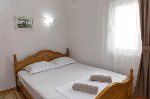 a bedroom with a bed with white sheets and a window at Villa Duraku in Ulcinj