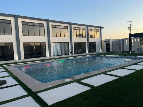 ein Schwimmbad vor einem Gebäude in der Unterkunft Pelicanos Residencial in Puerto Peñasco