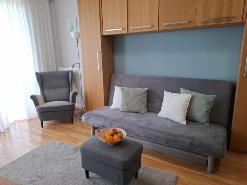 a living room with a couch and a bowl of fruit at Club 218 Balaton Apartman in Siófok
