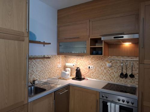 a kitchen with wooden cabinets and a counter top at Club 218 Balaton Apartman in Siófok