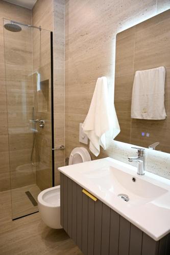 a bathroom with a sink and a toilet and a shower at Swiss Lux apartments in Durrës