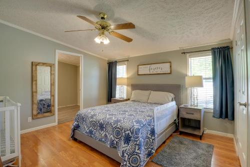 a bedroom with a bed and a ceiling fan at Noteworthy Cabin Grill, Walk to Beaver Lake! in Rogers
