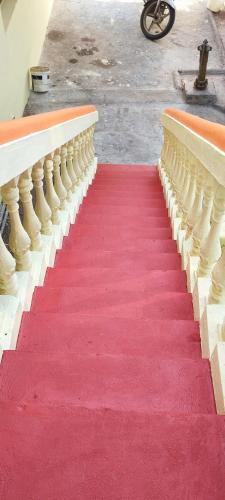 a red carpet on a staircase with a red carpet at Thillai Aura Homestay in Chidambaram