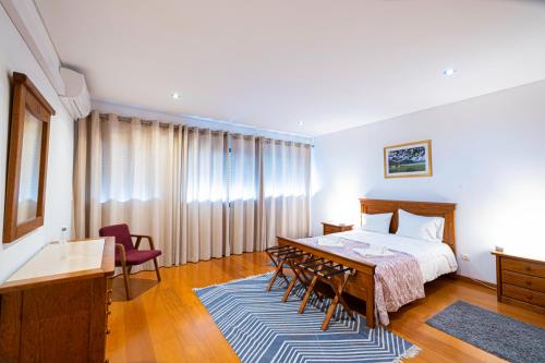 a bedroom with a bed and a table and chairs at Sailorman and Friends in Ponta Delgada